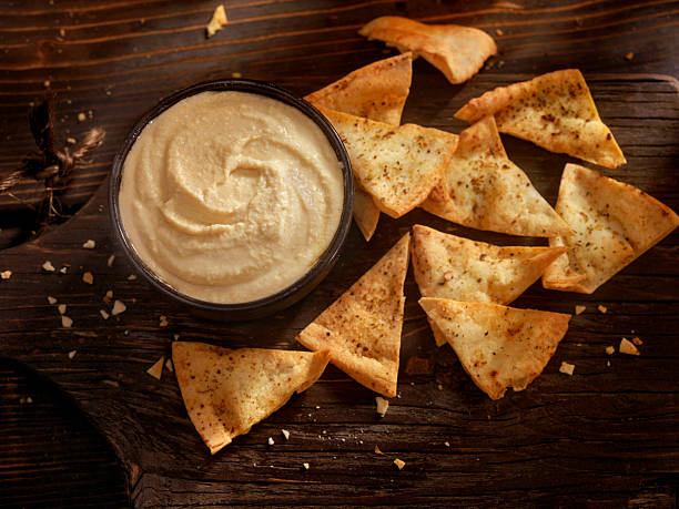 hummus con chips di pita al forno - hummus foto e immagini stock