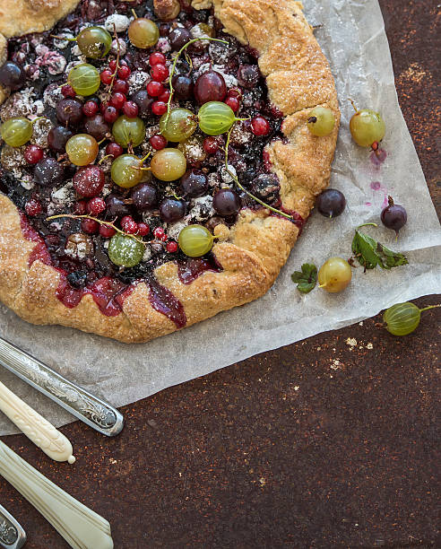 Crostata or galette pie with fresh garden berries over grunge Crostata or galette pie with fresh garden berries over grunge rusty metal background, top view, copy space crostata stock pictures, royalty-free photos & images