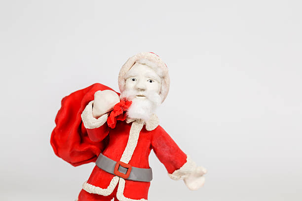 istock handmade clay Santa Clause, carry gift bag, in white background 495142374