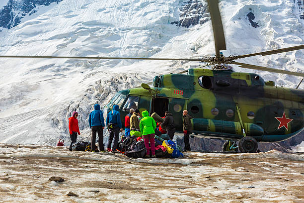 istock Helicopter Landing on Ice Field Massive Glacier People Unloading Luggage 495144036