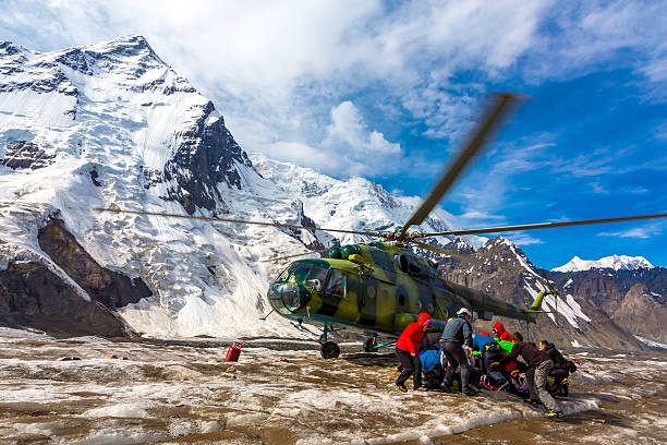 istock Helicopter Taking Off Ice Field Massive Glacier People Holding Luggage 495144374