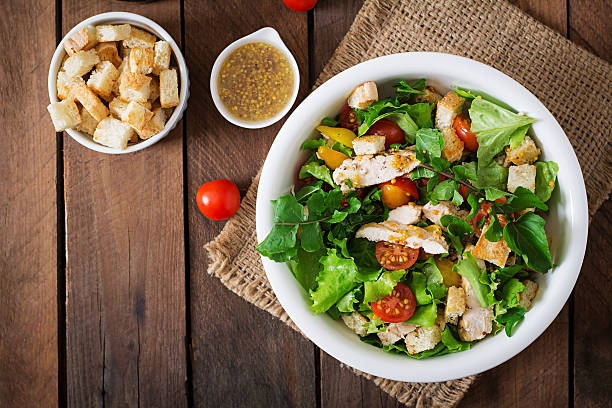 Fresh salad with chicken breast, arugula, lettuce and tomato. Fresh salad with chicken breast, arugula, lettuce and tomato. Top view spring mix lettuce leaves stock pictures, royalty-free photos & images
