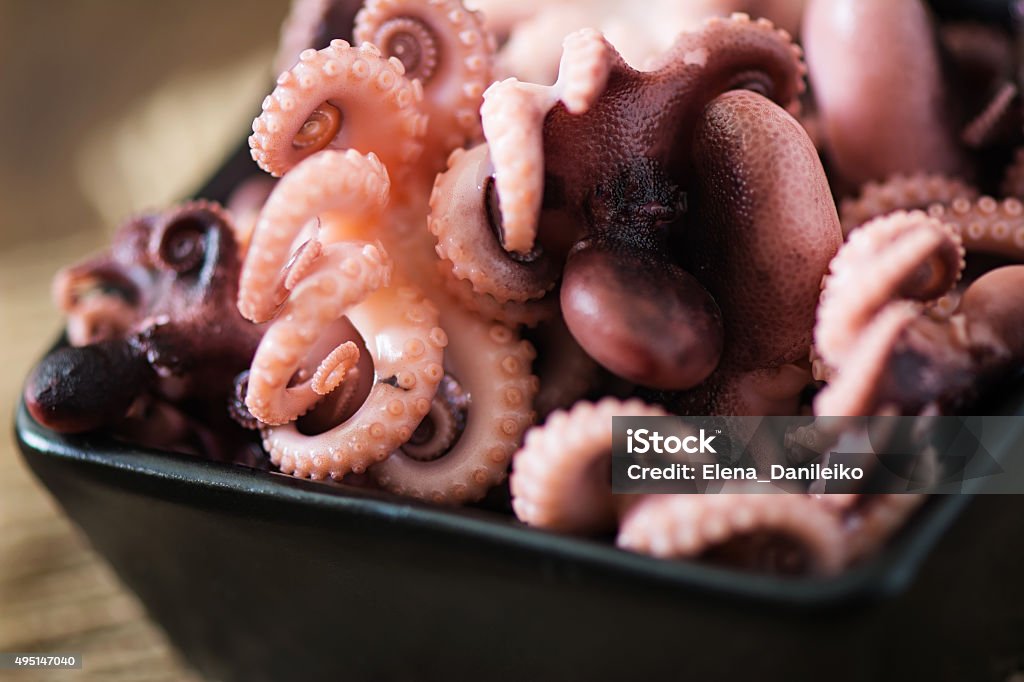 Boiled small octopus on a black plate 2015 Stock Photo