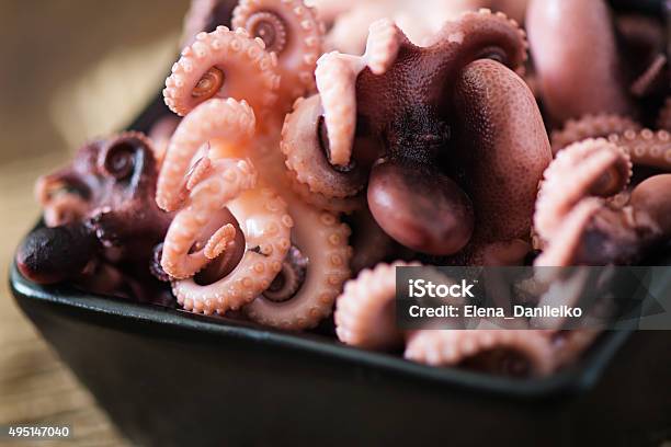 Boiled Small Octopus On A Black Plate Stock Photo - Download Image Now - 2015, Appetizer, Backgrounds