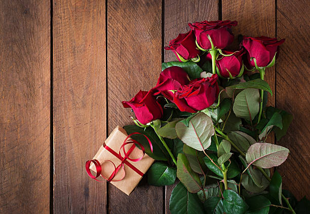 Bouquet of red roses on a dark  wooden background Bouquet of red roses on a dark  wooden background. Top view rose bouquet red table stock pictures, royalty-free photos & images