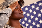 Patriotism: African descent military woman salutes American flag.