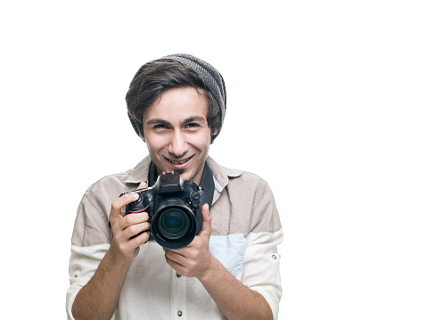 Smiling young casual man holding a DSLR Camera isolated on white. Image taken in studio with Hasselblad H5D and developed from Raw format