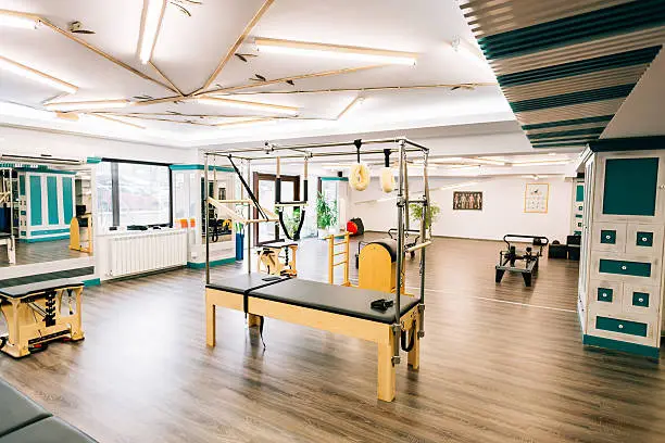 Pilates room with several devices like trapeze table, reformers, chairs etc