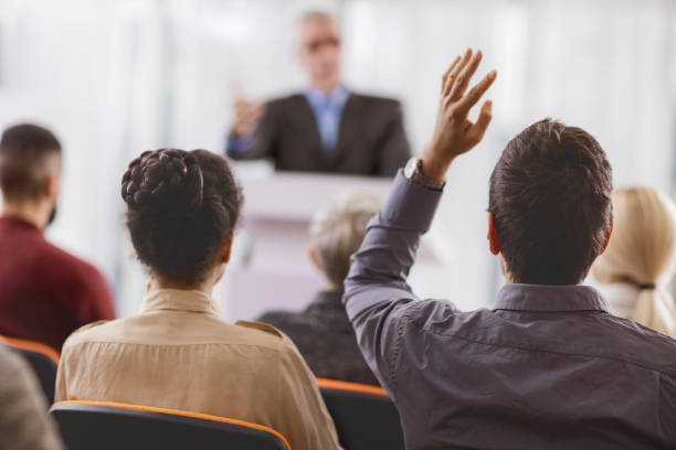 istock Rear view of an audience member asking a question. 495173334