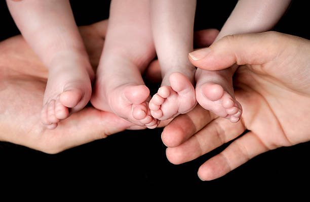istock Baby Twins Feet in parents hands 495176600