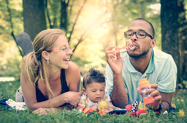 счастливая семья в парке в ретро фильтра эффект instagram - adoption family multi ethnic group human teeth стоковые фото и изображения