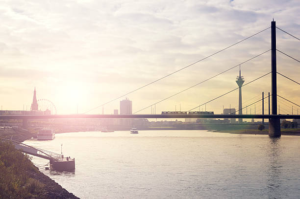 Bridge over the river rhine and skyline of Düsseldorf A bridge over the river rhine. A ferris wheel, part of the historic center, the Rhine-tower and a part of the Media-Harbour in the background, lens flare. düsseldorf stock pictures, royalty-free photos & images