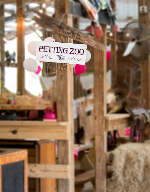 Petting Zoo Sign This is a photograph of the petting zoo sign.  Seen in the background are balloons and a party area. petting zoo stock pictures, royalty-free photos & images