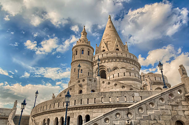 The Fisherman's Bastion Budapest, Hungary - September 19, 2015: The Fisherman's Bastion in Budapest, Hungary. The bastion is located right behind the Matthias Church in the Castle District. Designed by architect Frigyes Schulek and built between 1899 and 1905, the white-stoned Fisherman's Bastion is a combination of neo-Gothic and neo-Romanesque architecture and consists of turrets, projections, parapets, and climbing stairways. Its seven towers represent the seven Magyar tribes that settled in the Carpathian Basin in 896. fishermens bastion photos stock pictures, royalty-free photos & images