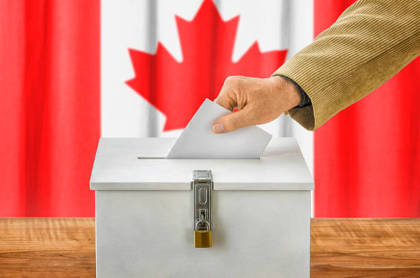 istock Man putting a ballot into a voting box - Canada 495190358