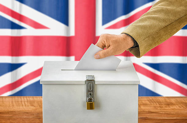 istock Man putting a ballot into a voting box - UK 495190388