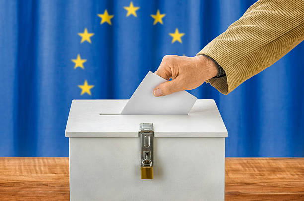 istock Man putting a ballot into a voting box - EU 495190416