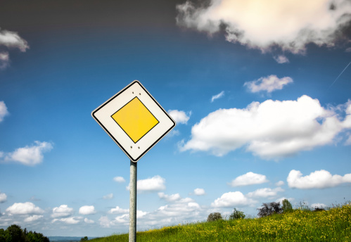 priority road sign (4) with blue sky and clouds