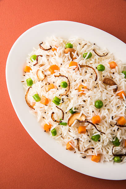 istock Indian Pulav or vegetables rice or veg biryani  orange background 495200804