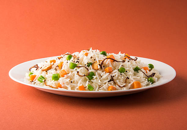 Indian Pulav or vegetables rice or veg biryani  orange background stock photo
