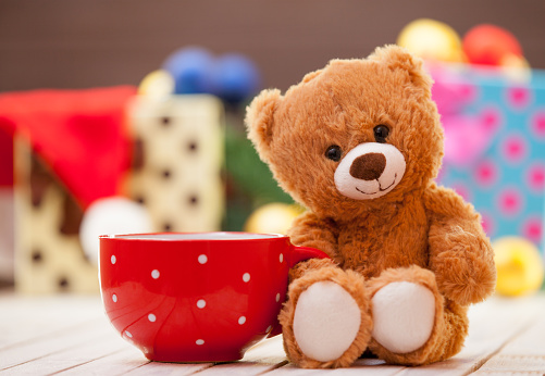 Teddy bear with cup of coffee or tea on christmas background