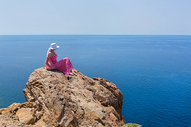 istock Woman  sit on a cliff. Greece, Santorini. 495203518