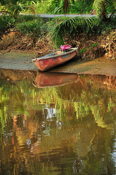 Reflection of a boat near the river bank stock photo