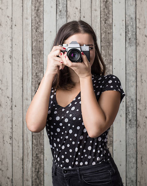 istock Young woman taking photograph with an slr camera 495204502