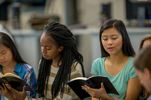 High School Students Studying Scripture Together A multi-ethnic group of high school age students are sitting together reading the Bible together during a Bible study. Bible stock pictures, royalty-free photos & images