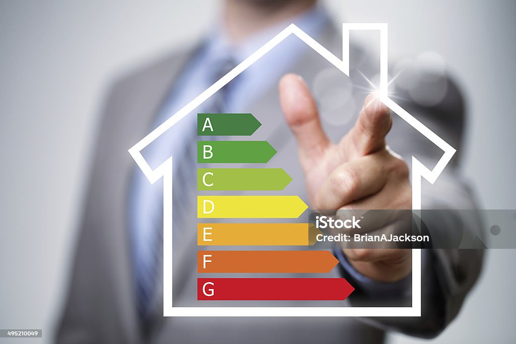 Energy efficiency in the home Businessman pointing to energy efficiency rating chart and house icon concept for performance, efficiency and environmental conservation Fuel and Power Generation Stock Photo