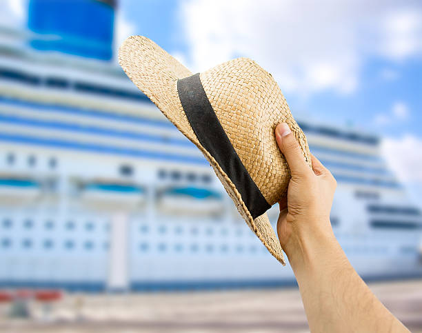 detail of hand holding the hat gesturing the greeting to the people of the cruise ship