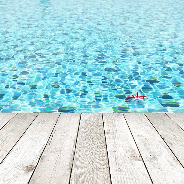 istock Wood plank over swimming pool water background - spa concept 495214639
