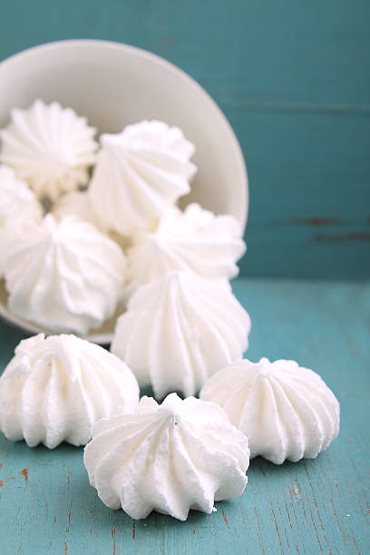 istock white meringue cake scattered on a blue wooden background 495227826
