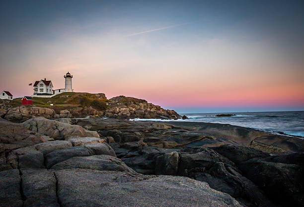 meer und leuchtturm auf felsigen küste bei sonnenuntergang - maine flag nubble lighthouse new england stock-fotos und bilder