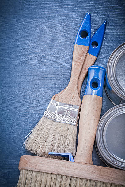 istock Set of paint brushes cans on wooden board construction concept 495230474