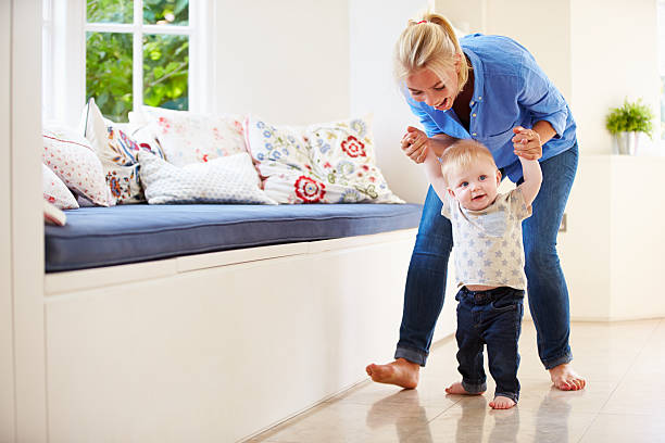 istock Mother Helping Young Son As He Learns To Walk 495235117