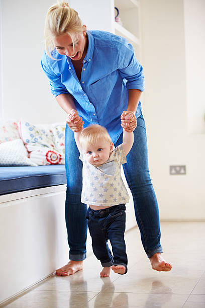 istock Mother Helping Young Son As He Learns To Walk 495235129