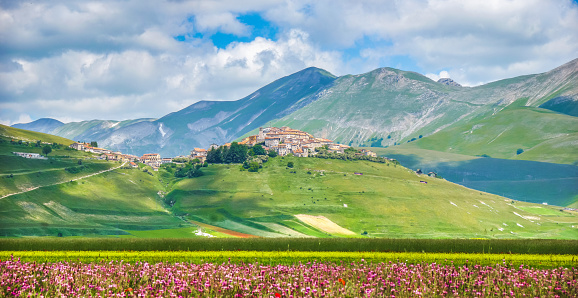 Historic city of Castelluccio di Norcia with beautiful summer landscape at Piano Grande (Great Plain) mountain plateau in the Apennine Mountains, Umbria, Italy