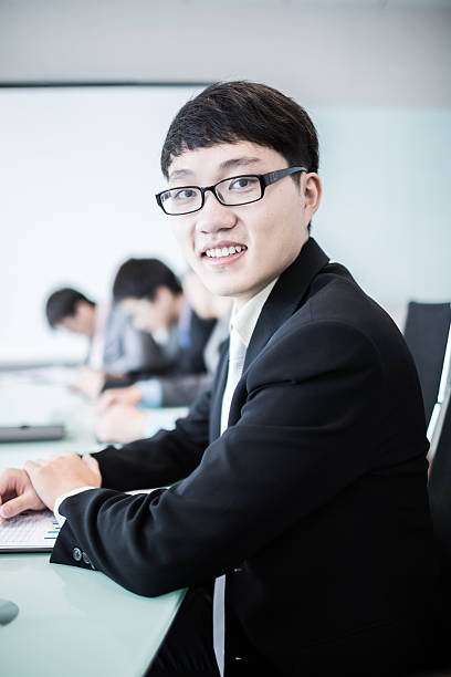 istock Businessman smiling at the camera while his team is working 495240223