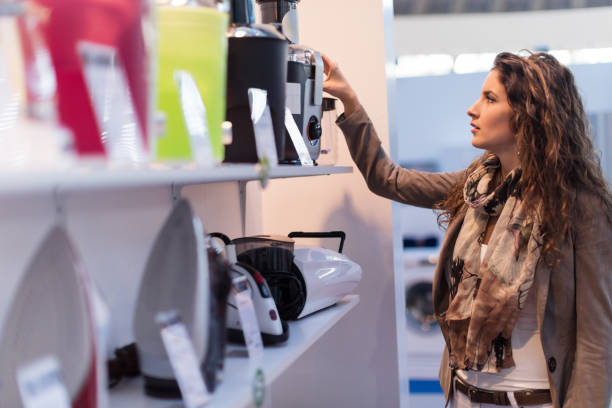 Choosing electric juicer Beautiful woman choosing new electric juicer in homeware store kitchenware shop stock pictures, royalty-free photos & images