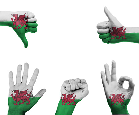 A set of hands with different gestures wrapped in the flag of Wales