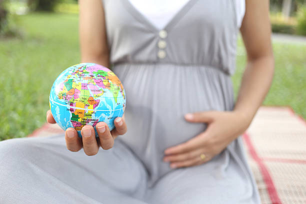 istock Pregnant women show Globe model in hand. 495242232