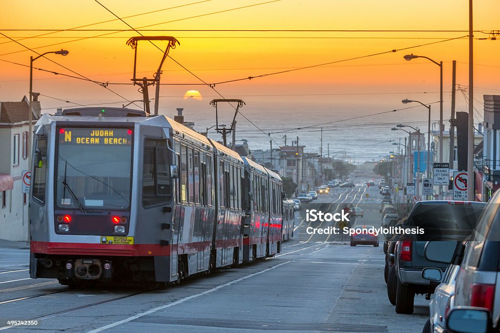 San Francisco lightrail drive to  the sea under Sunset A group of light rail cars makes their way through San Francisco's Outer Sunset neighborhood. Pacific ocean on the background. San Francisco - California Stock Photo