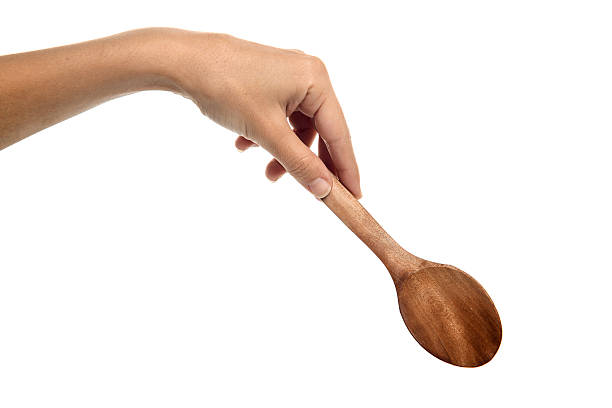 Wooden spoon in hand wooden spoon on a white background wooden spoon stock pictures, royalty-free photos & images