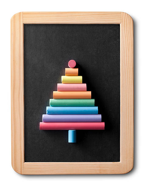 Colorful chalks on a blackboard Blackboard with colorful chalks shaped Christmas tree. lavagna stock pictures, royalty-free photos & images