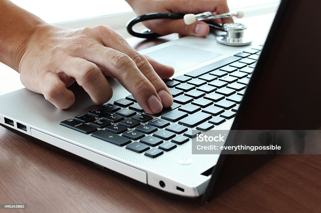 Doctor working with laptop computer in medical workspace office Doctor hand working with laptop computer in medical workspace office as concept 2015 Stock Photo