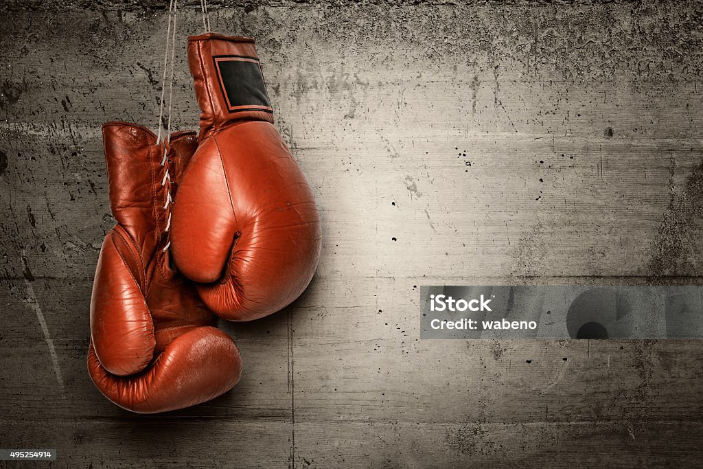 Boxing gloves hanging on concrete wall Boxing gloves hanging on concrete wall -including clipping path Boxing - Sport Stock Photo