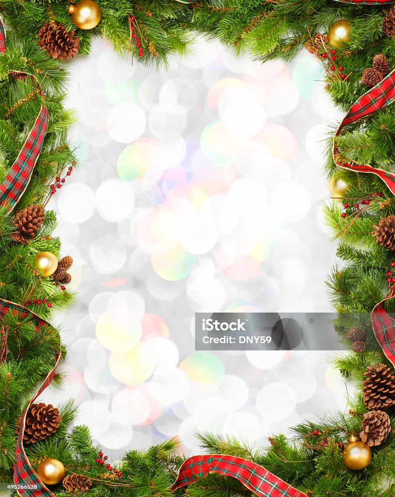 Christmas Garland Frame In Front Of Blurred Lights A frame created by Christmas garland. The christmas garland is in front of pastel blurred lights.  There is room for text in center of frame. Border - Frame Stock Photo