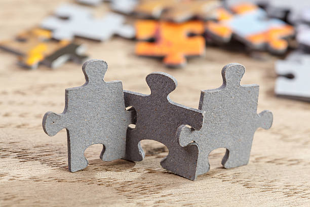 Three Jigsaw Puzzle Pieces on Table stock photo