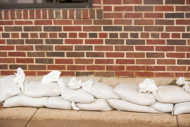 Natural disasters. Flooding. Sandbags line building wall. Natural disasters. Sandbags line the side of a brick building in anticipation, preparation of the rising flood waters caused by recent severe thunderstorms in Texas, USA. Floods. flood preparation stock pictures, royalty-free photos & images